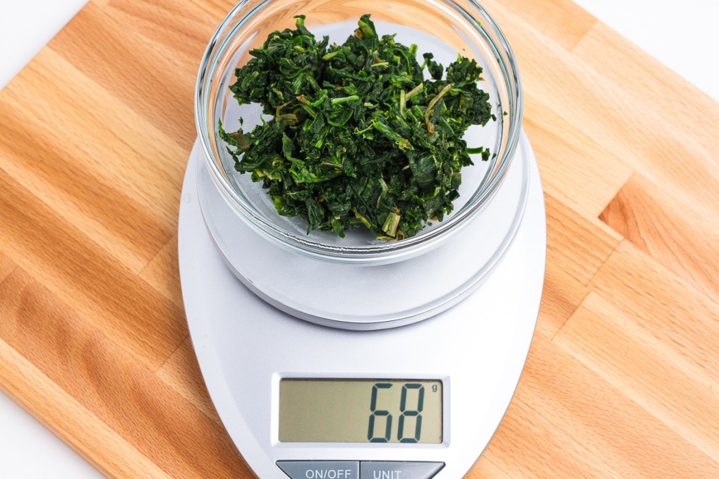 Rinse the frozen spinach under hot water to quickly thaw 68 grams of thawed chopped spinach