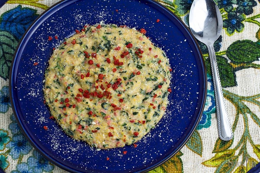 This backpacking meal will stomp your tongue and stick to your ribs Parmesan spinach and bacon grits on a blue plate