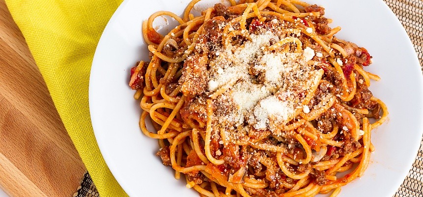 a bowl of spaghetti with parmesan cheese sprinkled on top