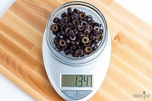 134 grams sliced black olives on a scale